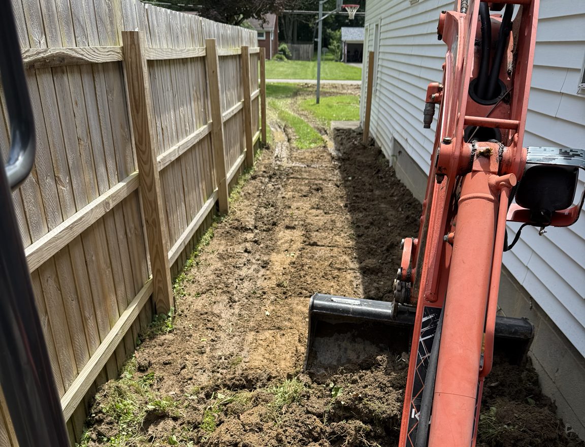 View from the FP Projects mini excavator cab digging along a fence line